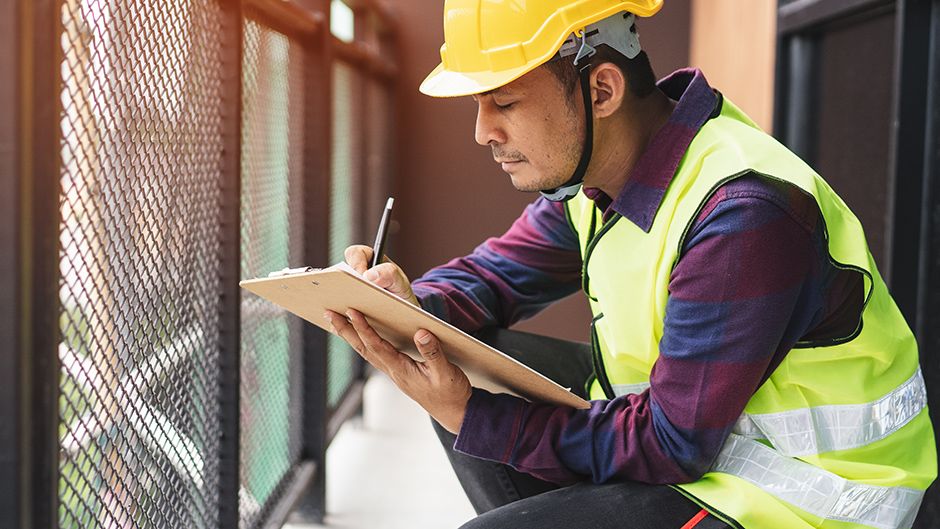 A person in safety clothing inspecting a building