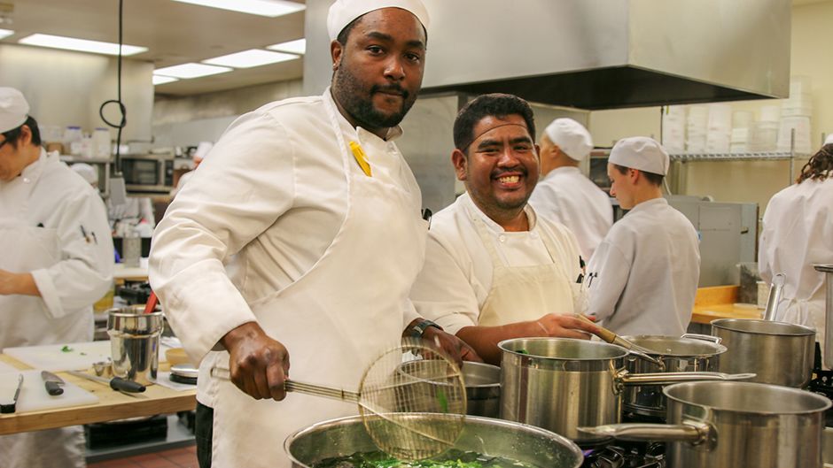 Students working in a kitchen culinary school setting