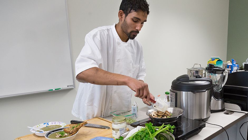 A student cooking a meal in a classroom setting