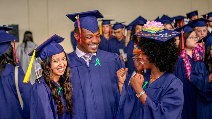 Three graduating CRC students in their caps and gowns