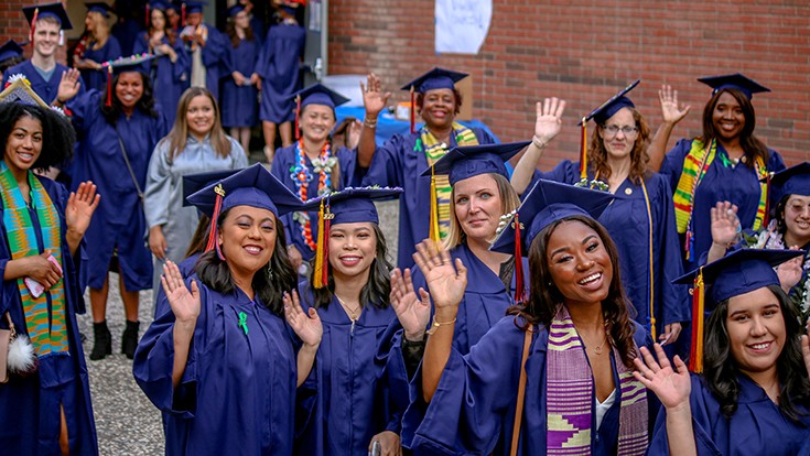 CRC graduates gathering outside in their cap and gowns