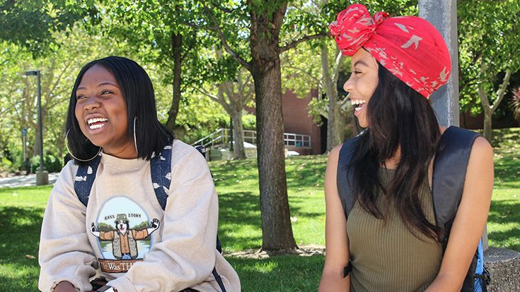 Two students laughing together on campus