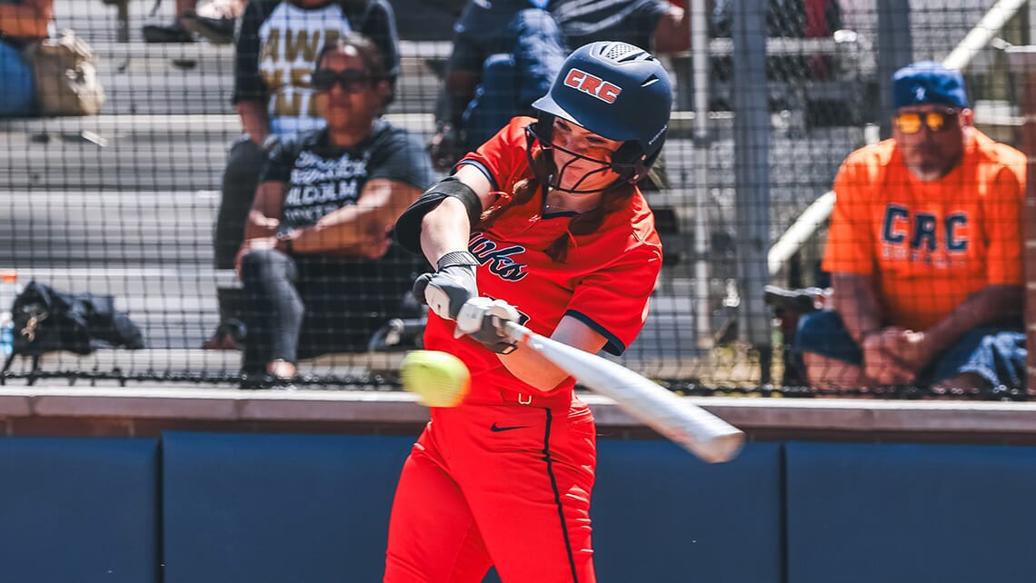 CRC softball player hitting the ball