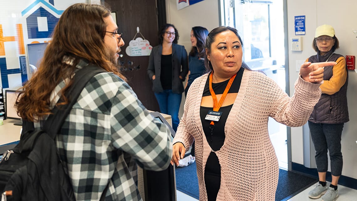 A person giving directions to a student inside the Hawk CARES Center