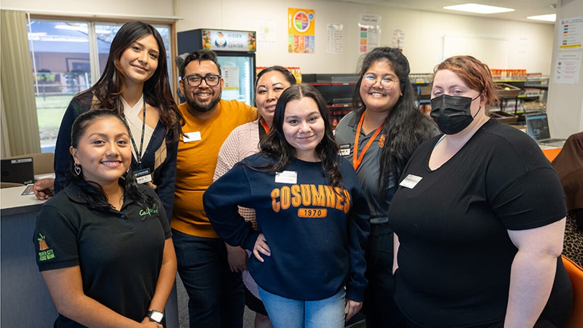 Six people inside the Hawk CARES Center, smiling at the camera, ready to assist