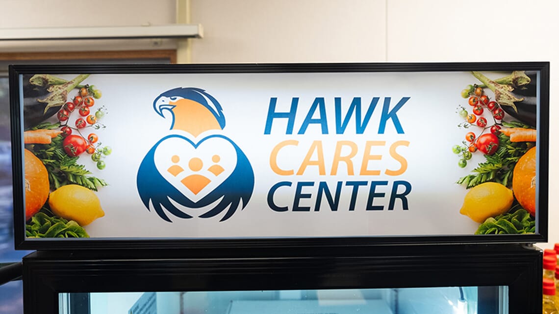 An electron billboard with the words Hawk CARES Center and a logo depicting a hawk wrapping its wings around a heart