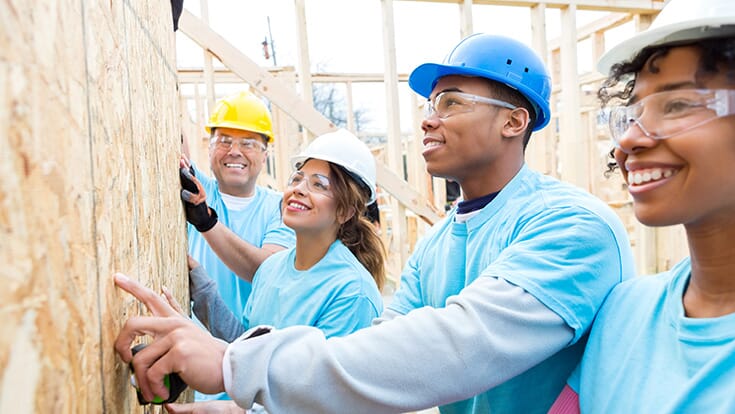Students wearing hard hats learning about framing