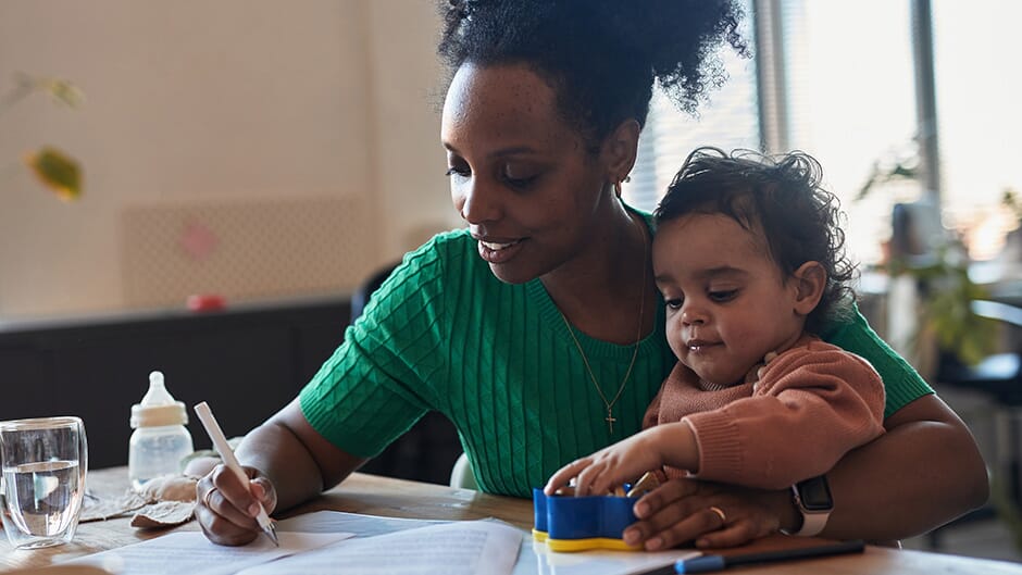 Mother holding her child while studying