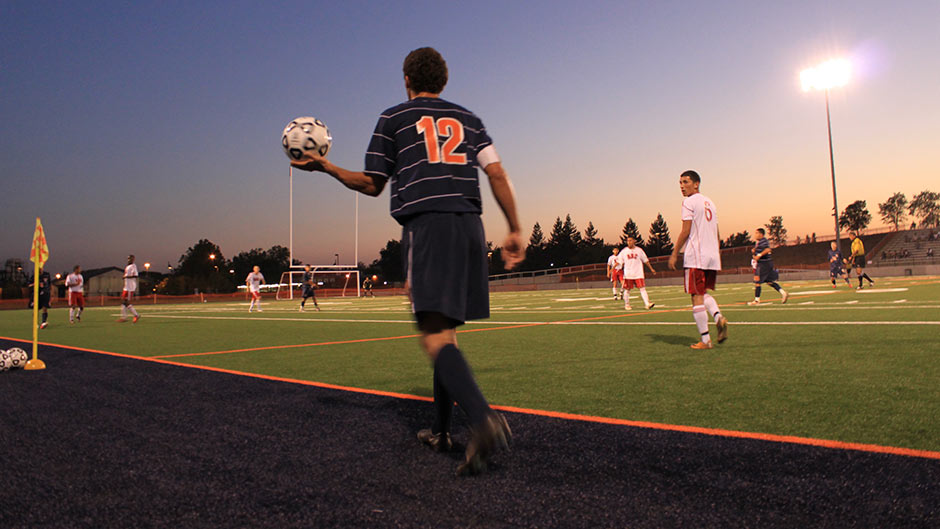 Mens soccer player throwing ball in from side line